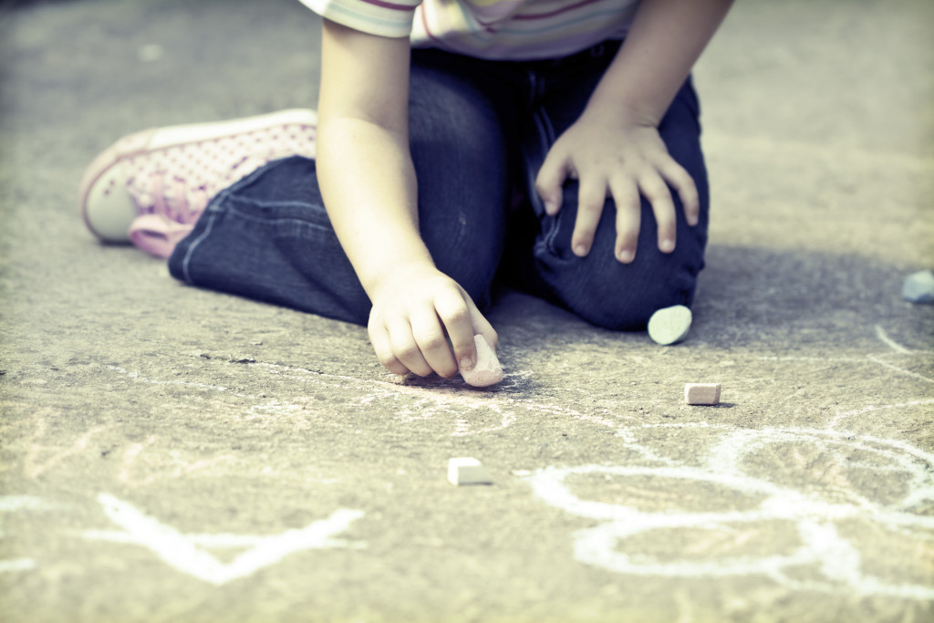 Photo of girl writing with chalk on the schoolyard